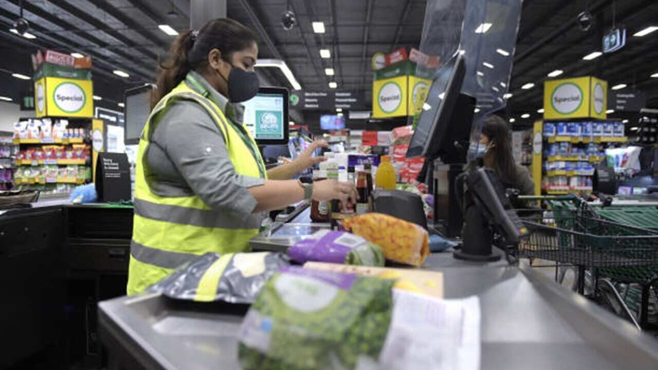 An employee scans goods at a check-out counter inside a Woolworths Group Ltd. grocery store in Melbourne, Australia.jpg