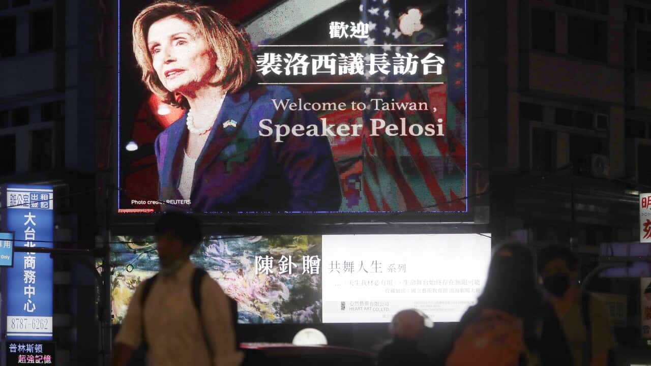 People walk past a billboard welcoming Nancy Pelosi, in Taipei, Taiwan