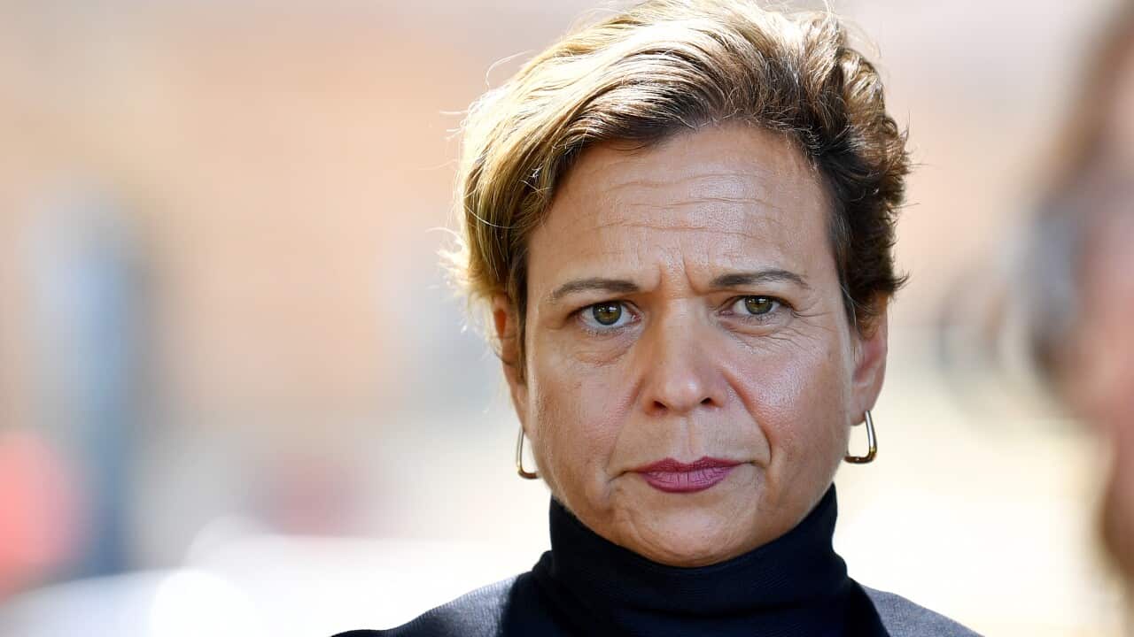 A woman in a black top looking serious