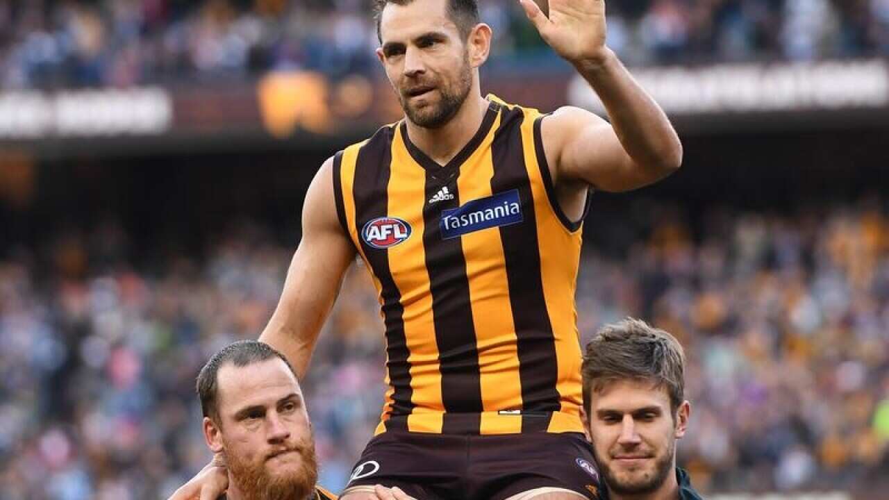 Hawthorn player Luke Hodge is carried from the ground.