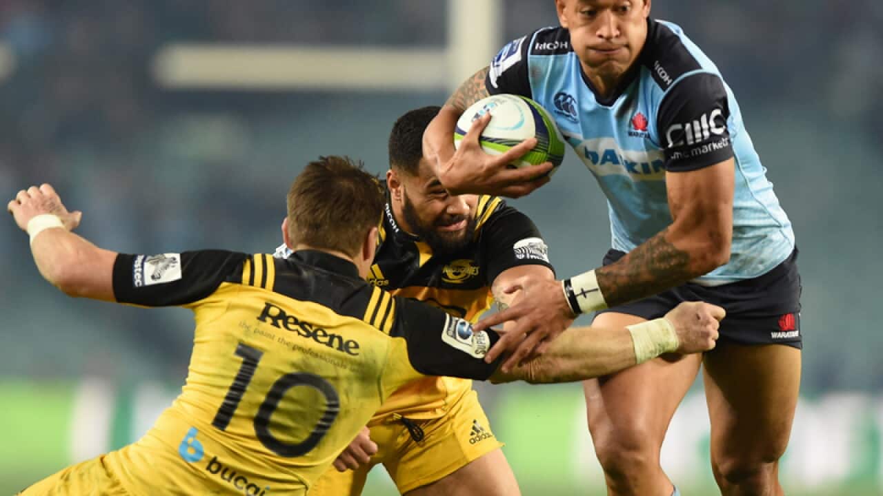 Israel Folau of the Waratahs pushes through the Hurricanes defence