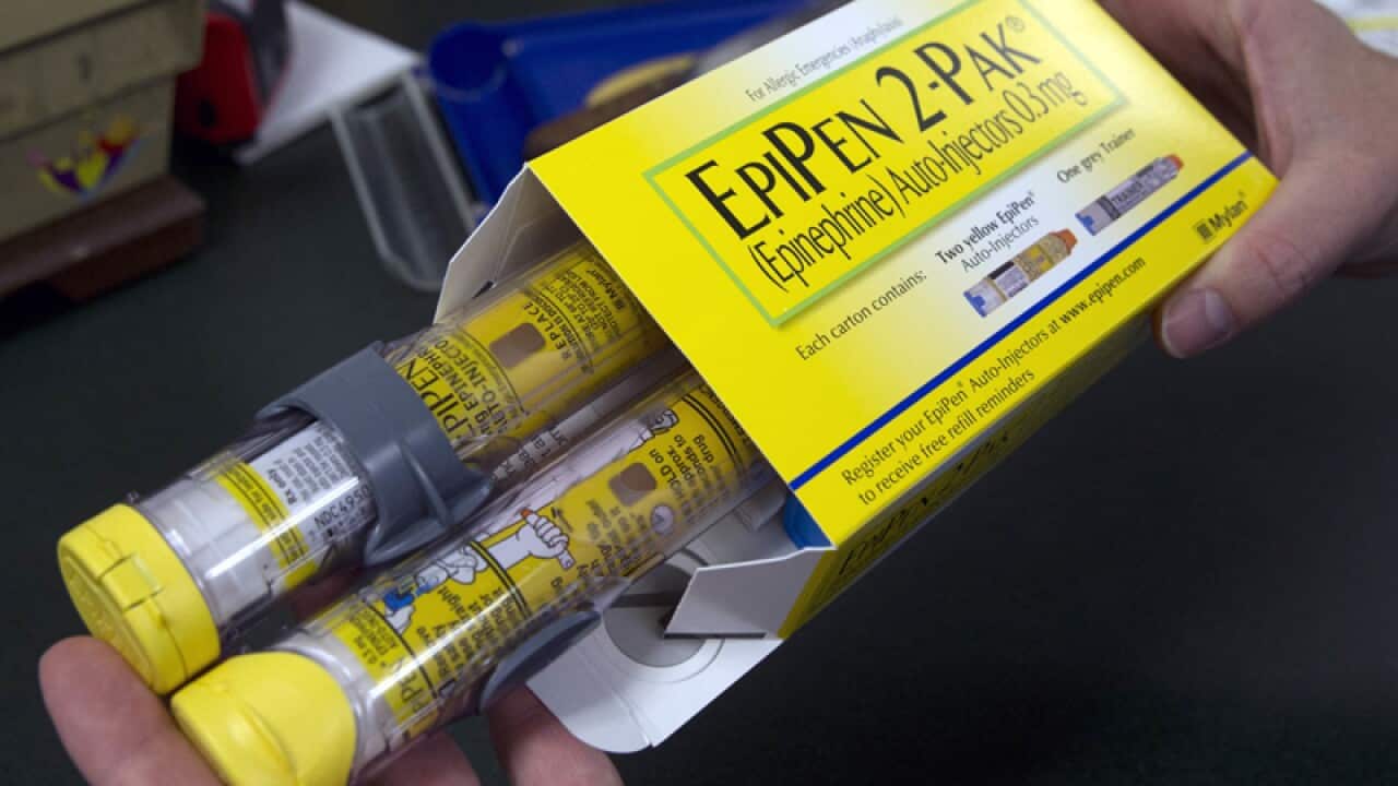 A pharmacist holds a package of EpiPens
