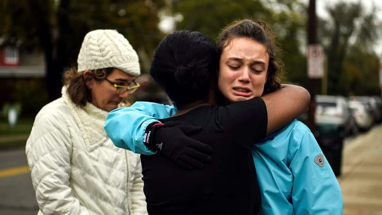 Friends and family hug after a deadly shooting at a Pittsburgh synagogue.