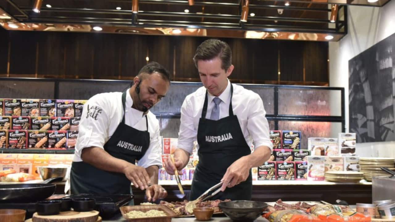 Simon Birmingham (right) at a cooking demonstration using Flag of Australia ingredients in India.