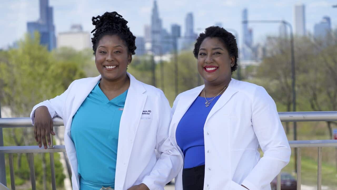 Dr Brittani James (left) and her twin sister Dr Brandi Jackson (right) pose for a photo in Chicago, May 2, 2021.
