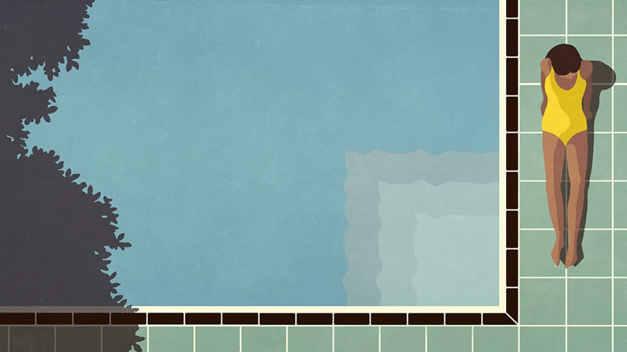 Woman in yellow bathing suit sunbathing at sunny, summer poolside