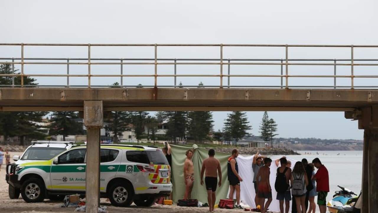 Rescue crews attend the scene of a drowning at glenelg beach.