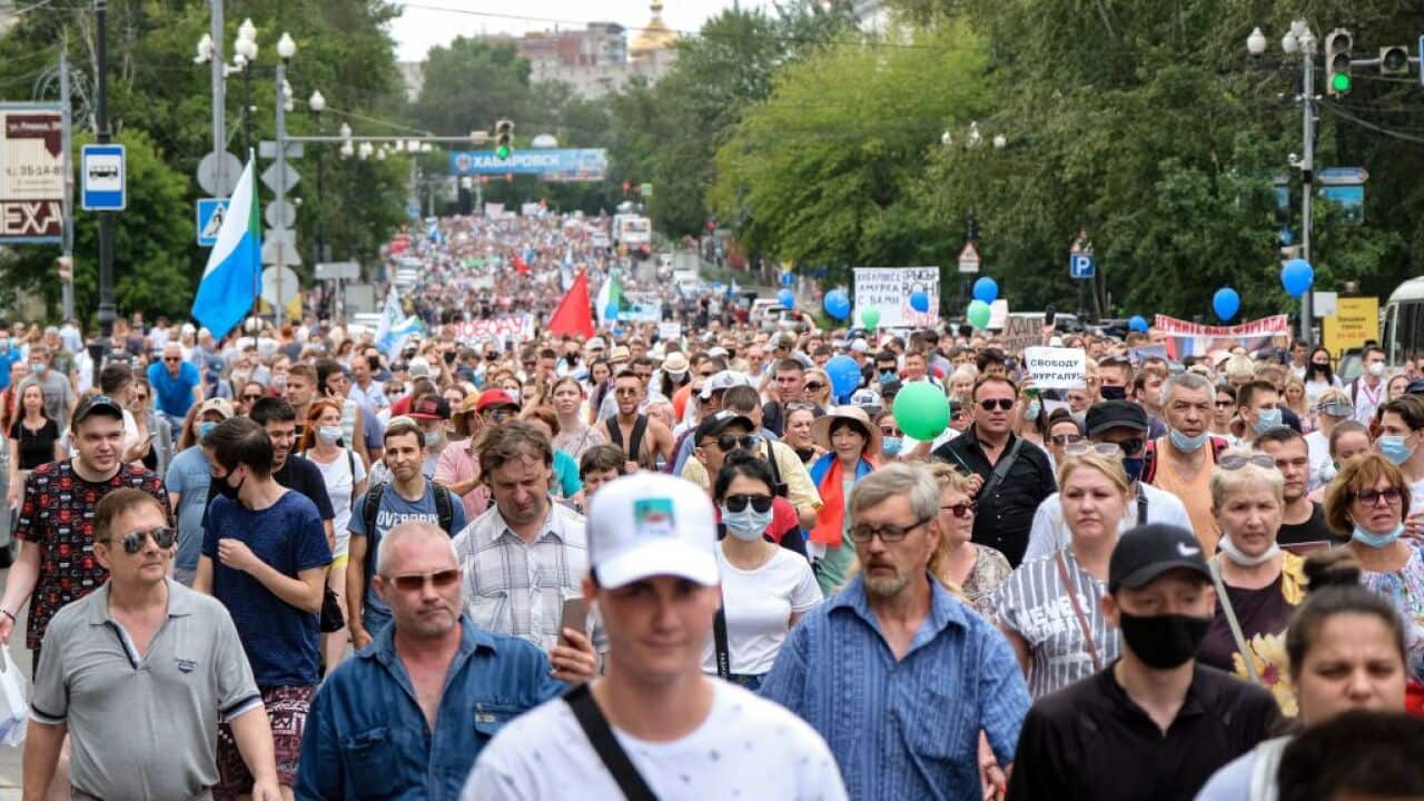 People hold banners and signs during the rally