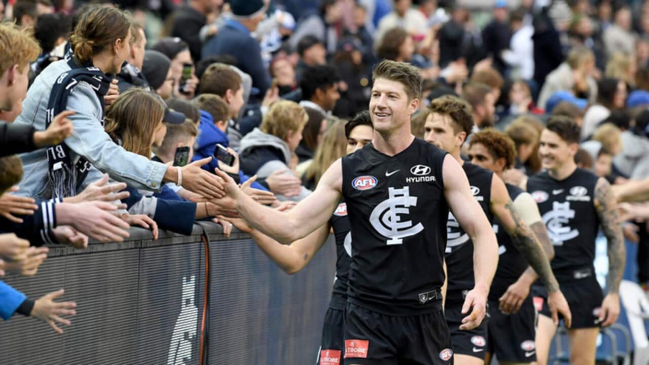 Carlton players celebrate with fans after beating Essendon