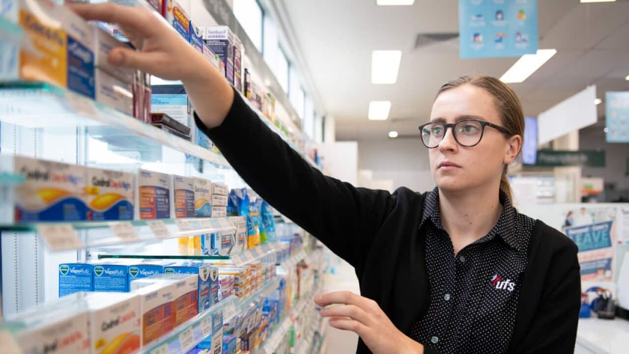 A pharmacist reaches for medicine at a shop in Coburg, Melbourne