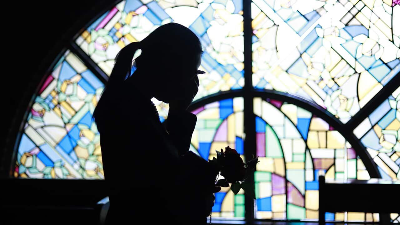 Silhouette woman crying against stained glass