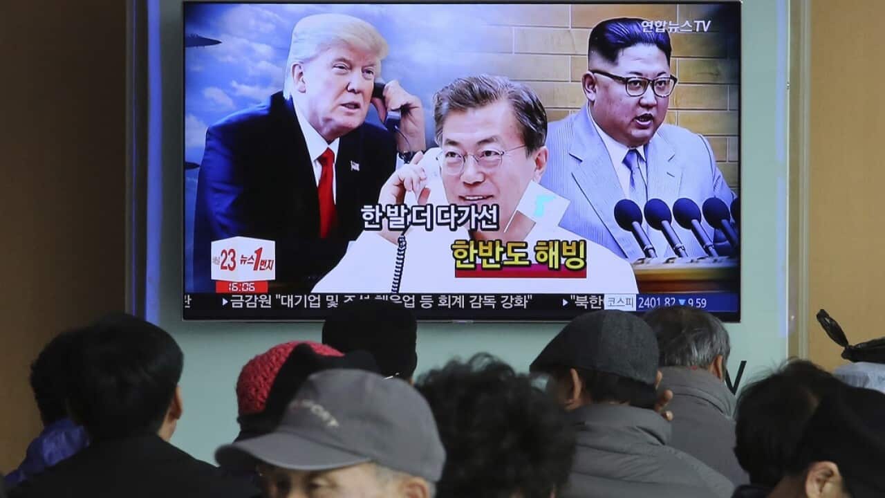 People watch a TV screen showing images of Kim Jong-un, right, Moon Jae-in, centre, and Donald Trump at the Seoul Railway Station.