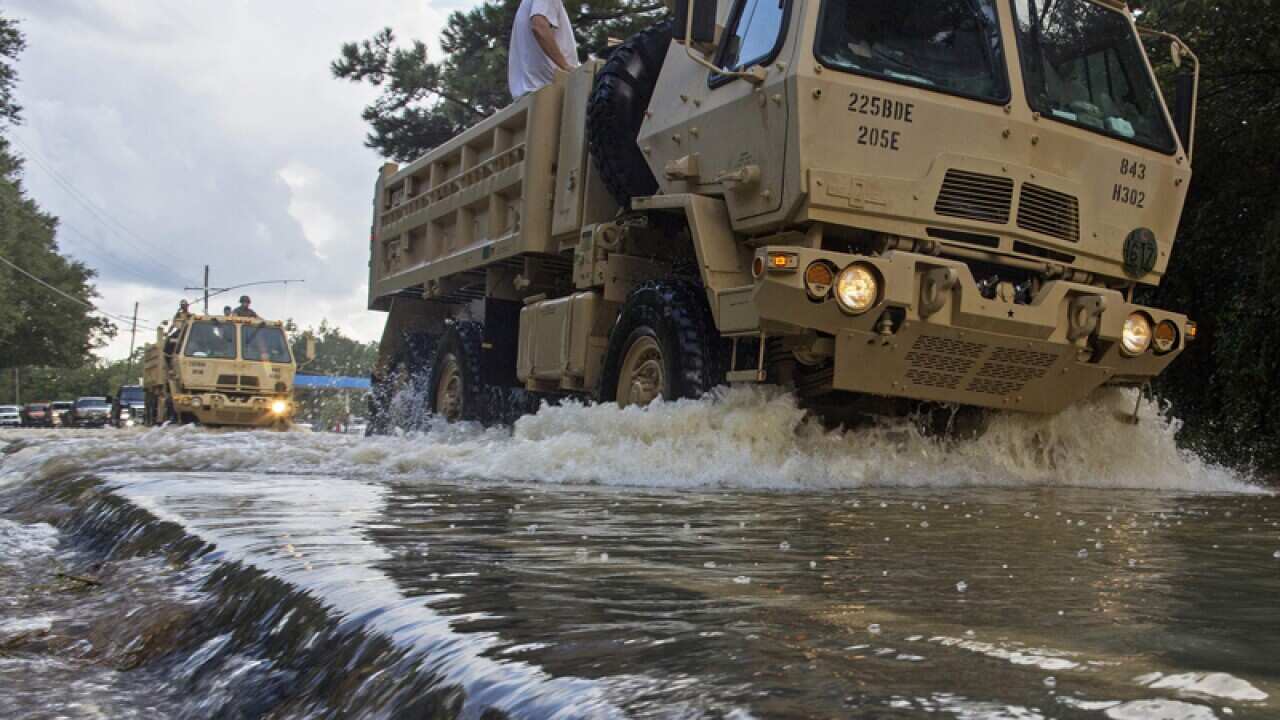 The Louisiana National Guard transport people out of floodwaters