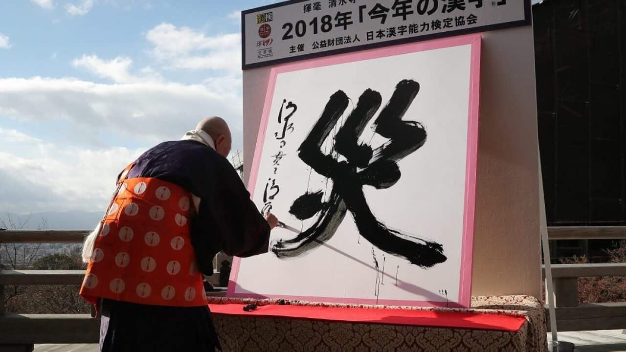 Seihan Mori, chief Buddhist priest of the Kiyomizu-dera temple, writes the Chinese character meaning 'disaster' at the temple in Kyoto.