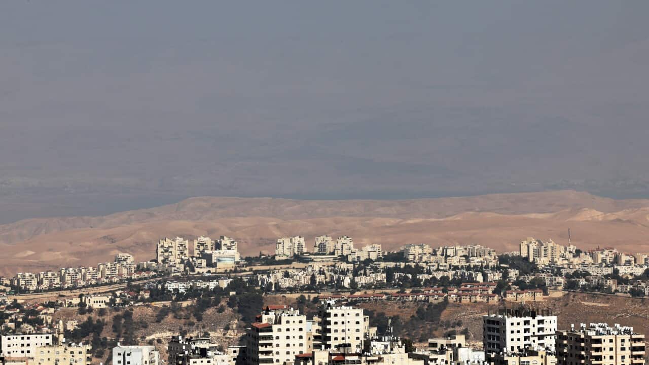 Rows of buildings below a mountainous skyline.