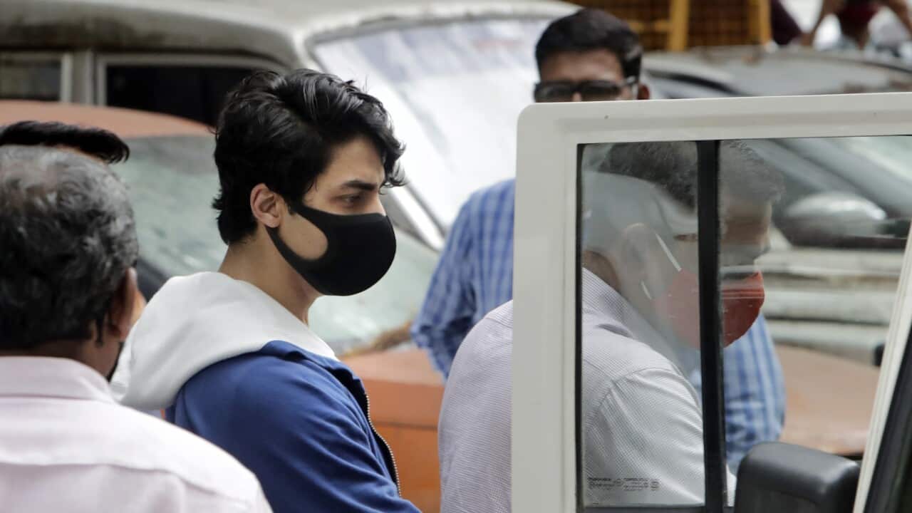 Bollywood actor Shah Rukh Khan's son Aryan Khan, center, escorted by law enforcement officials from Narcotics Control Bureau office is being taken for a medical check up, in Mumbai, India, Friday, Oct. 08, 2021.(AP Photo/Rajanish kakade)
