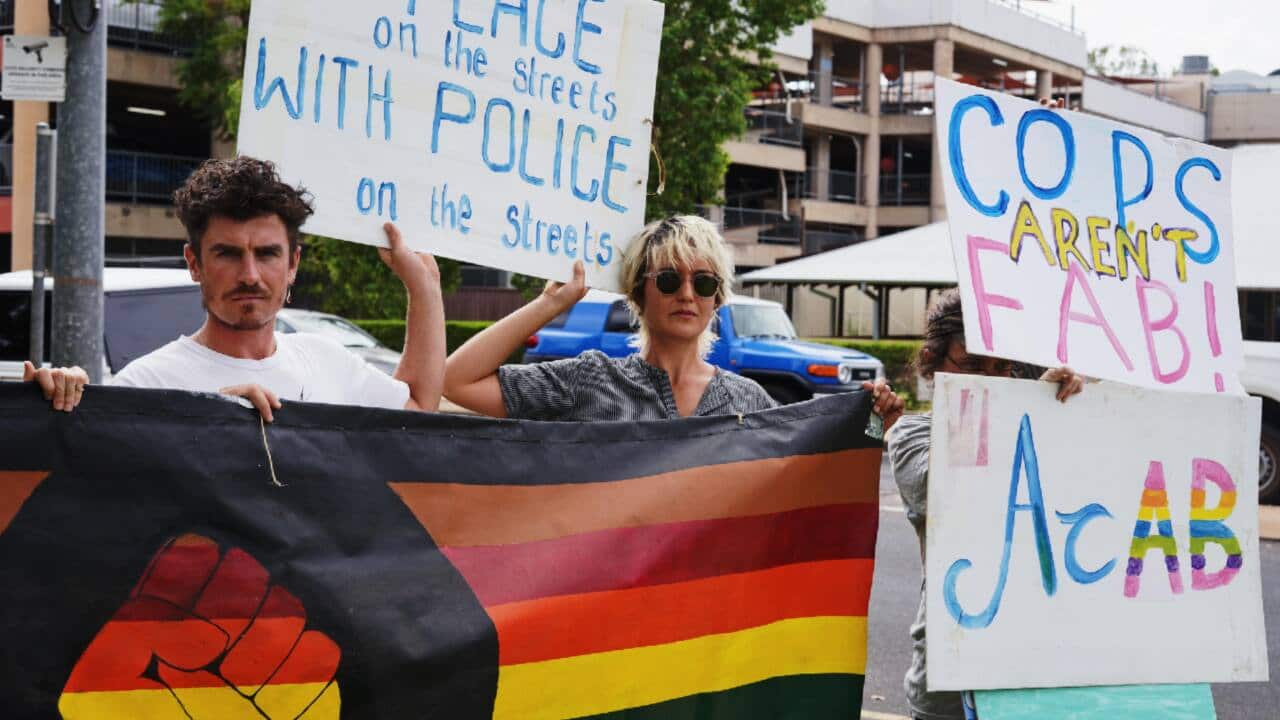 Some members of the LGBTIQA+ community protesting the rainbow flag being raised outside the Alice Springs Police Station.