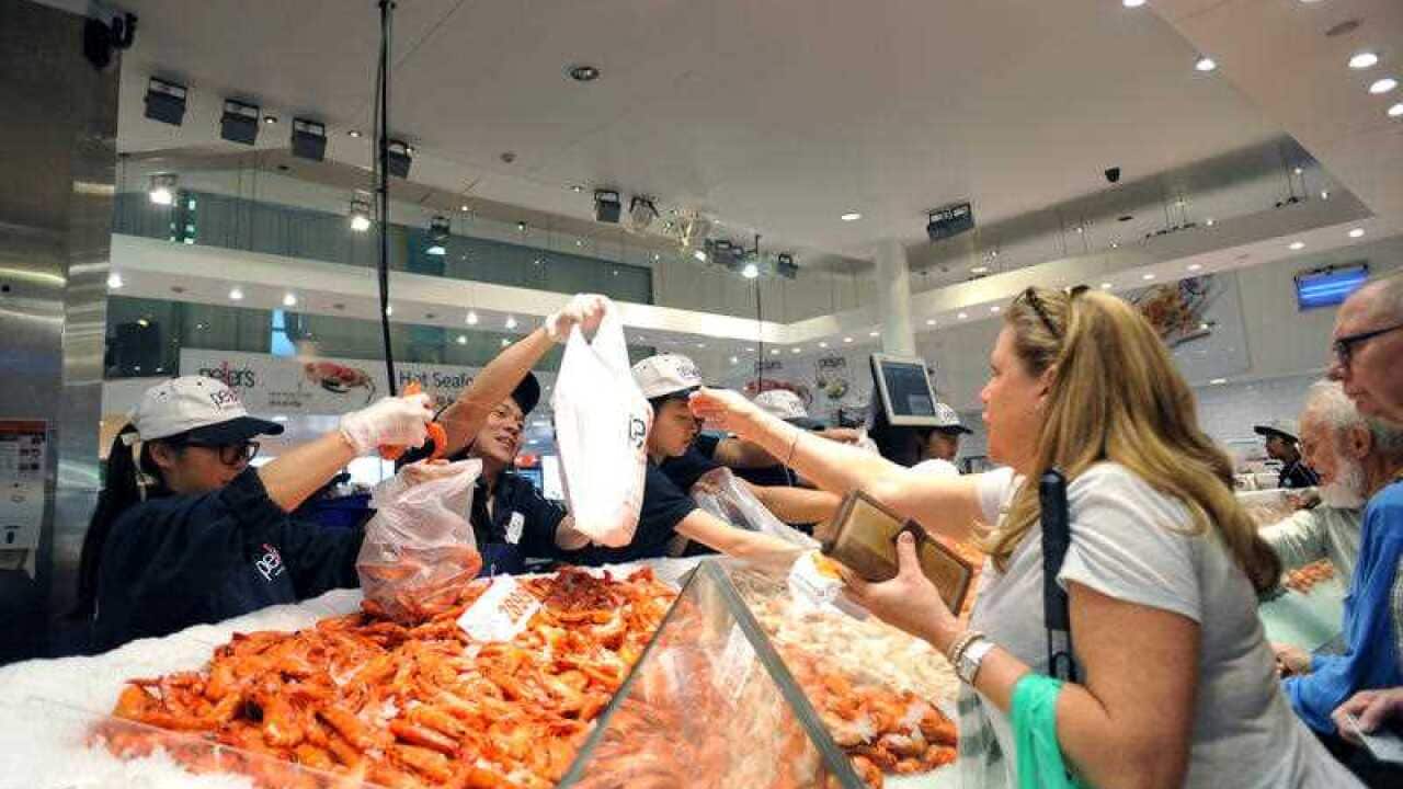Customers are seen purchasing seafood on Good Friday at the Sydney Fish Market, in Sydney