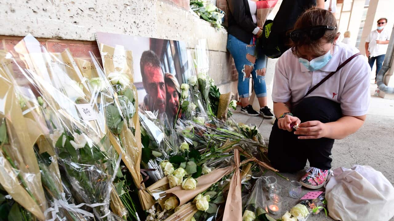 People leave flowers as thousands of people participate in a white march as a tribute to French bus driver Philippe Monguillot