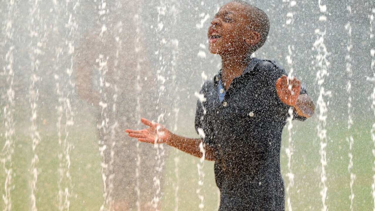 Azari Bland, 5, runs through the spray of the fountain at Johnnie W. Walker Park in Jackson, Florida to beat the heat wave. (AP)