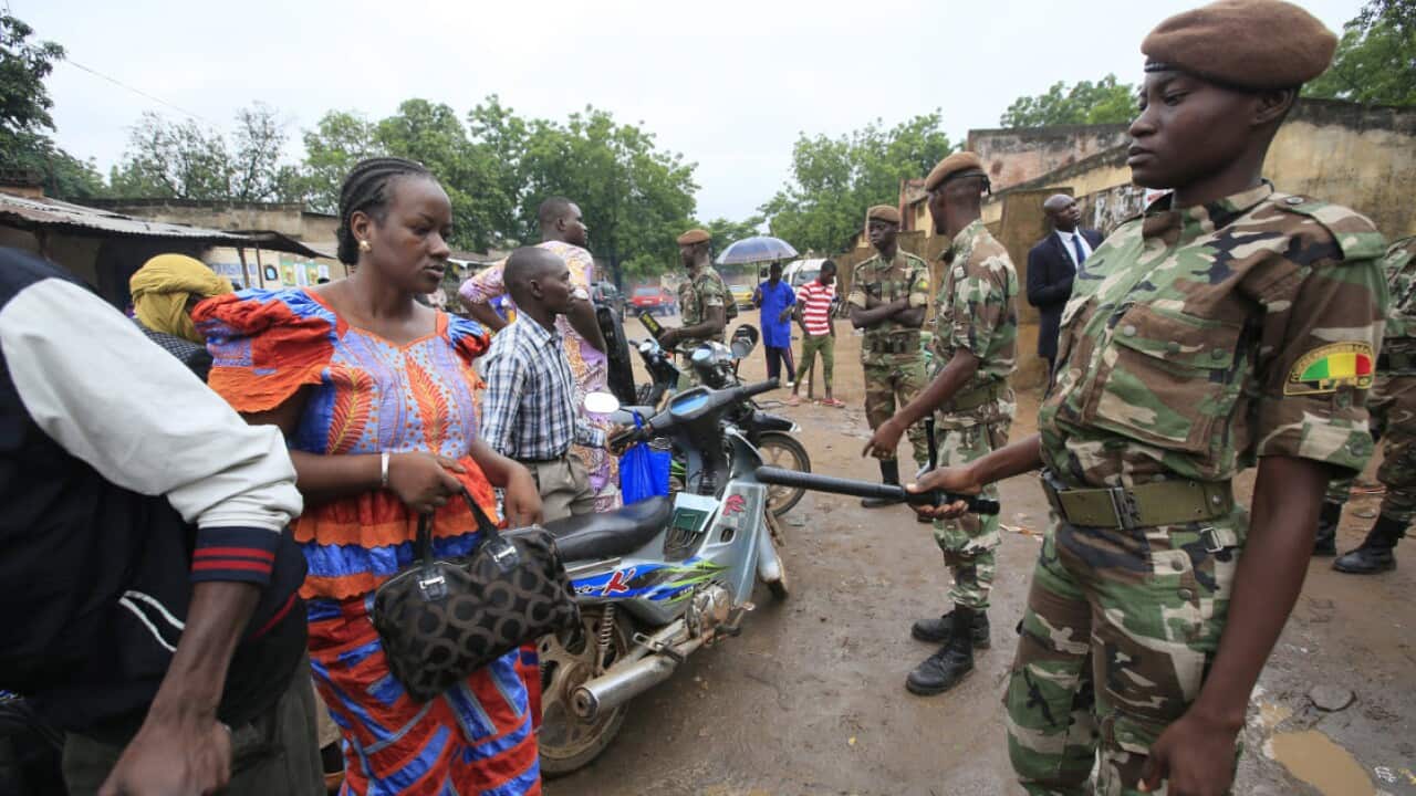 Malian soldiers stand guard at a polling station.