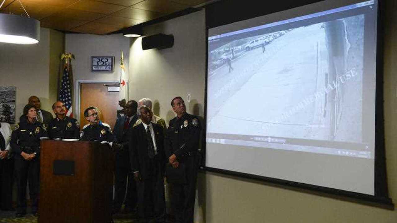 Authorities watch a video of the shooting scene at a news conference