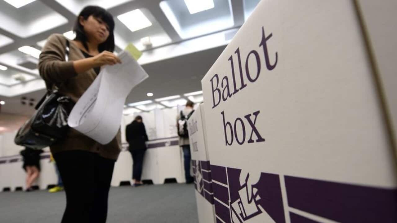 A woman casts her vote at a voting centre in Brisbane, Saturday, Sept. 07, 2013. Australians are voting for the 44th Parliament today. (AAP Image/Lukas Coch) NO ARCHIVING