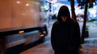 Faceless man with a black hoodie in the night city