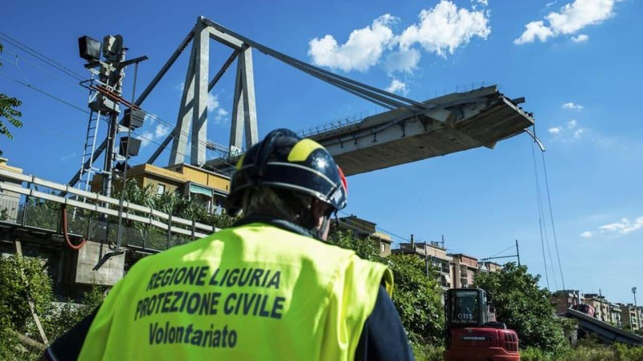 A worker inspects the the area around the collapsed Morandi bridge