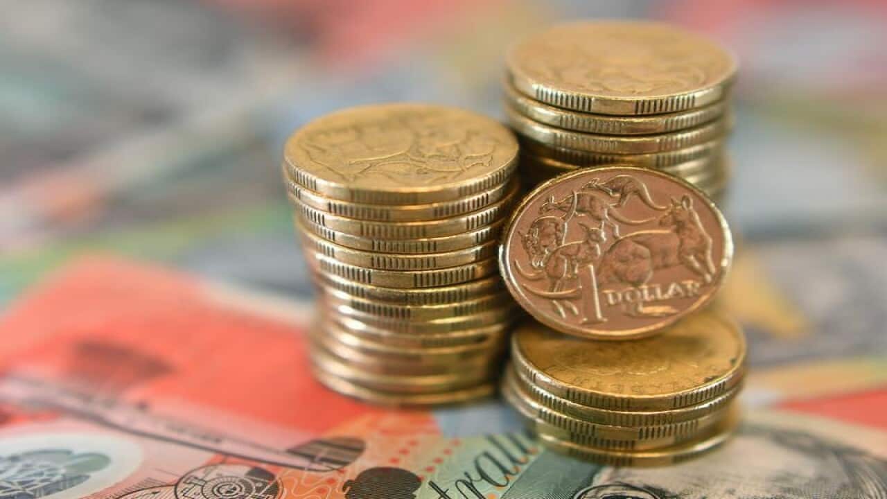 A close up of Australian dollars on top of a $20 note.