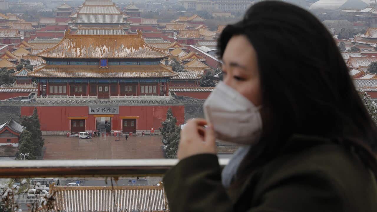 A woman wears a protective mask at Jingshan Park in Beijing.