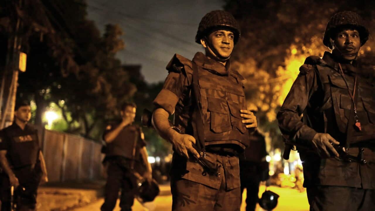 Bangladeshi security forces stand guard close to a Spanish restaurant