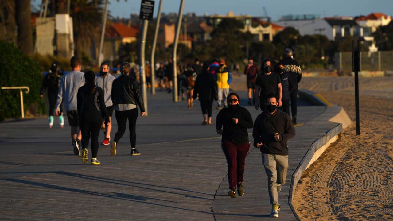 People are seen exercising along St Kilda beach in Melbourne, Monday, September 28, 2020.