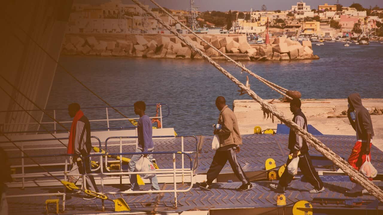 Refugees walking onto a boat