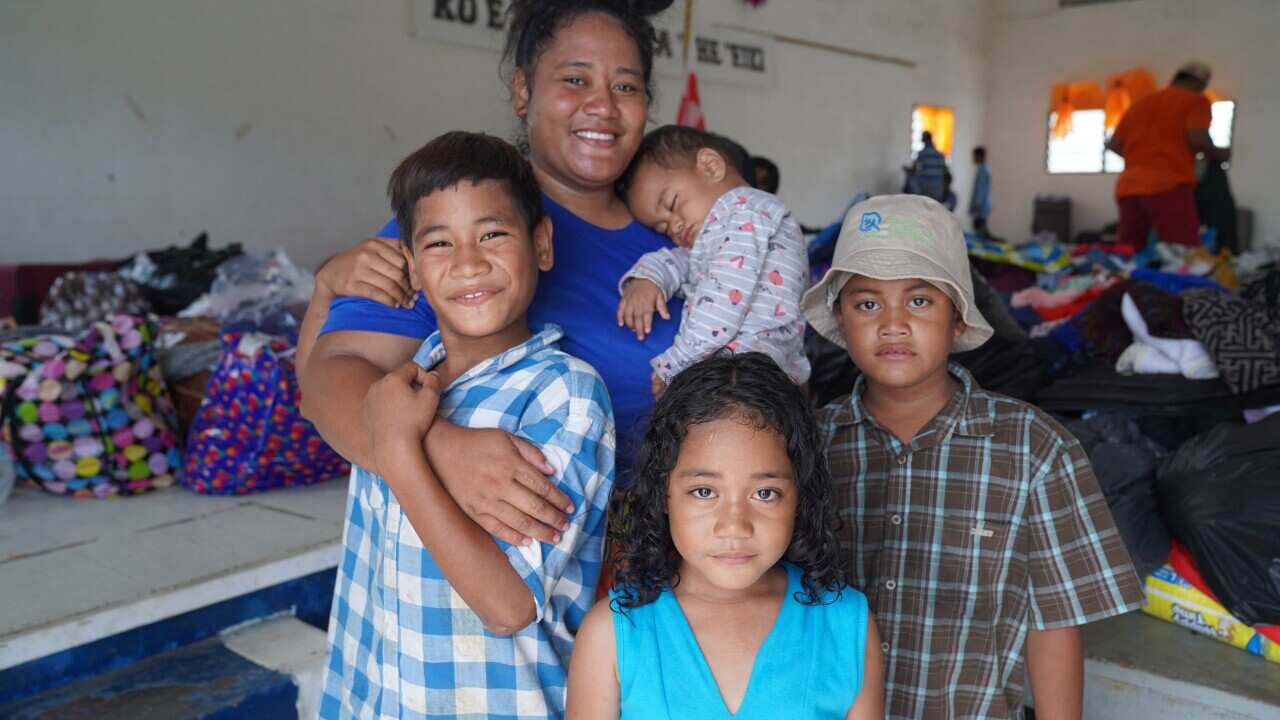 This photo taken on January 24, 2022 shows Mango Island evacuees posing as they receive clothing donations at the Free Wesleyan Church hall in Longolongo in Tonga's capital Nukualofa following the January 15 eruption of the nearby Hunga Tonga-Hunga Haapai