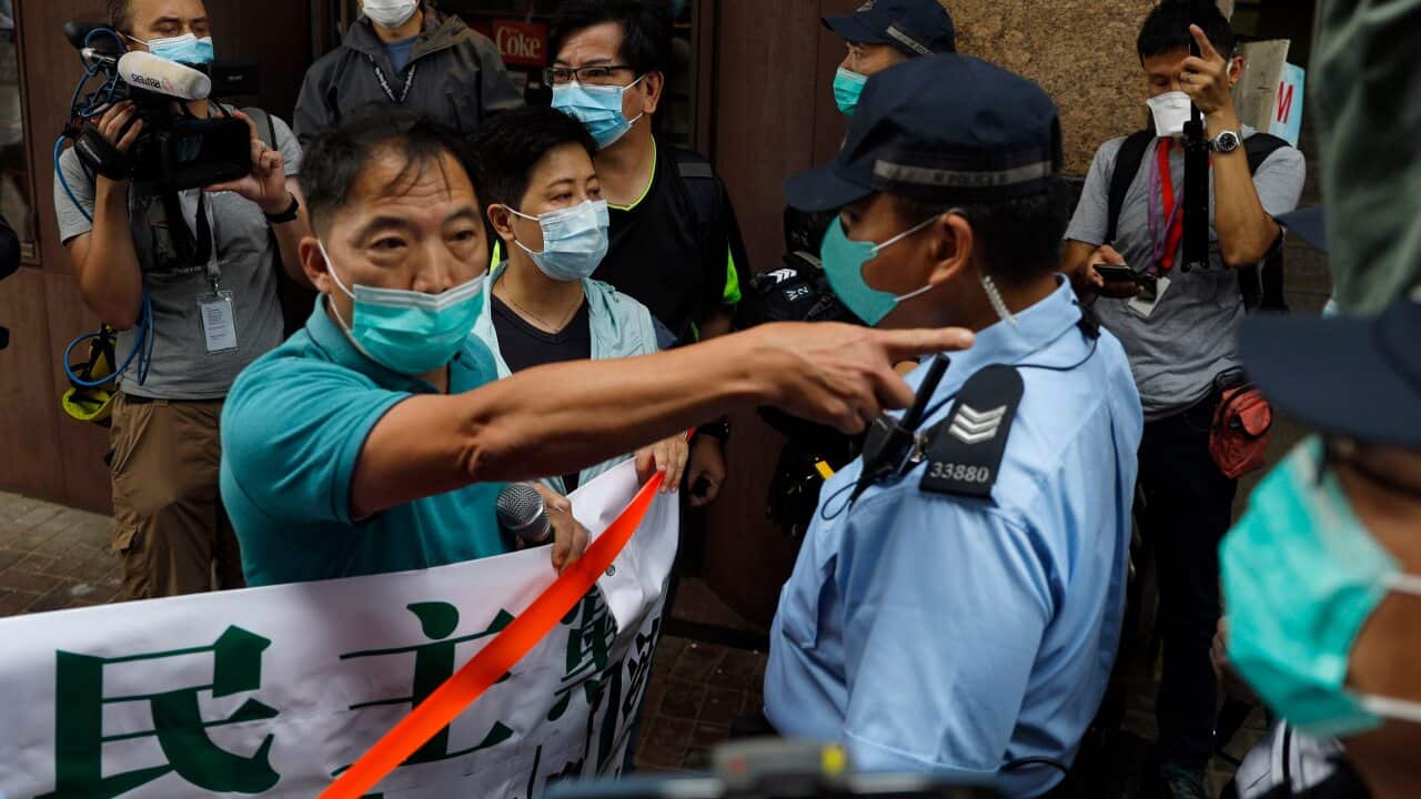 Police officers stop members of the Democratic Party moving forwards during a protest near the Chinese central government's liaison office in Hong Kong.