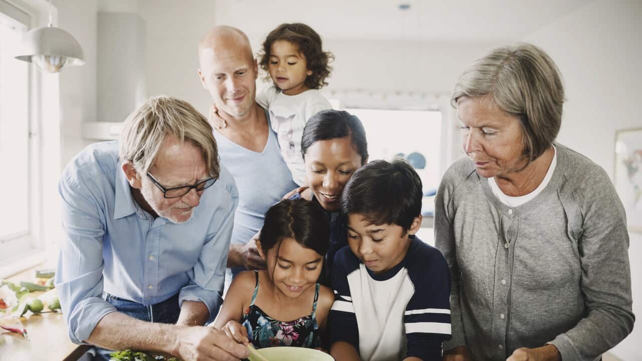 Multi-ethnic multigenerational family preparing food at kitchen counter