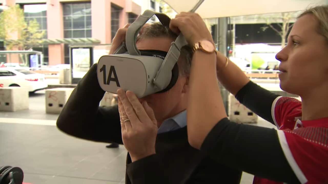 Allan Veitch puts on virtual reality goggles