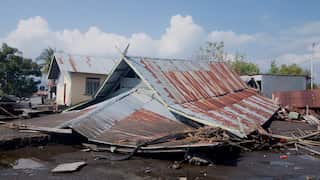 A collapsed house with only its roof visible.