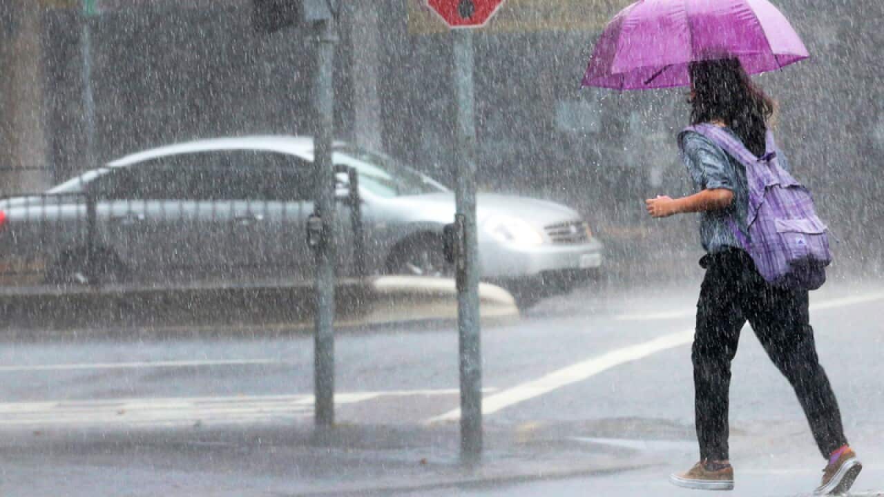A woman crosses the road during heavy rain