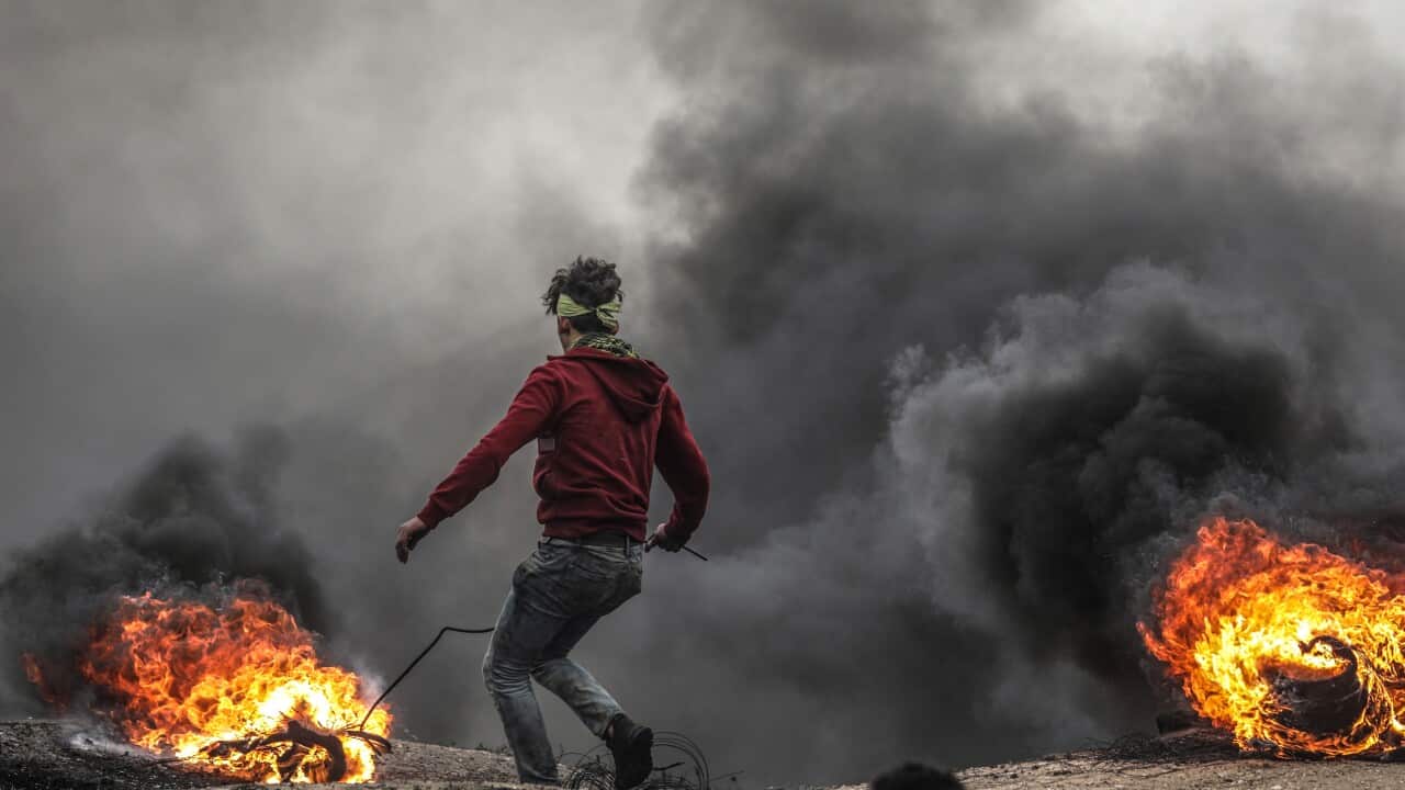 A Palestinian protester burns tires during the clashes near the border between Israel and Gaza Strip, eastern Gaza Strip.