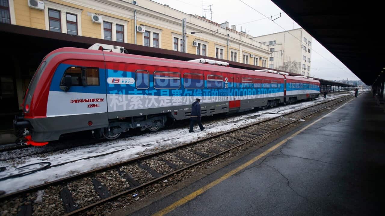  A railroad worker walks by the first train decorated with letters that read "Kosovo is Serbian" written in twenty languages