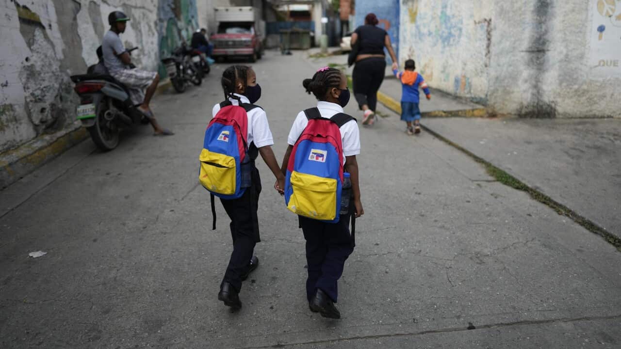 Girls walk to school on the first day back to in-person classes since the start of COVID-19 pandemic restrictions in Caracas, Venezuela