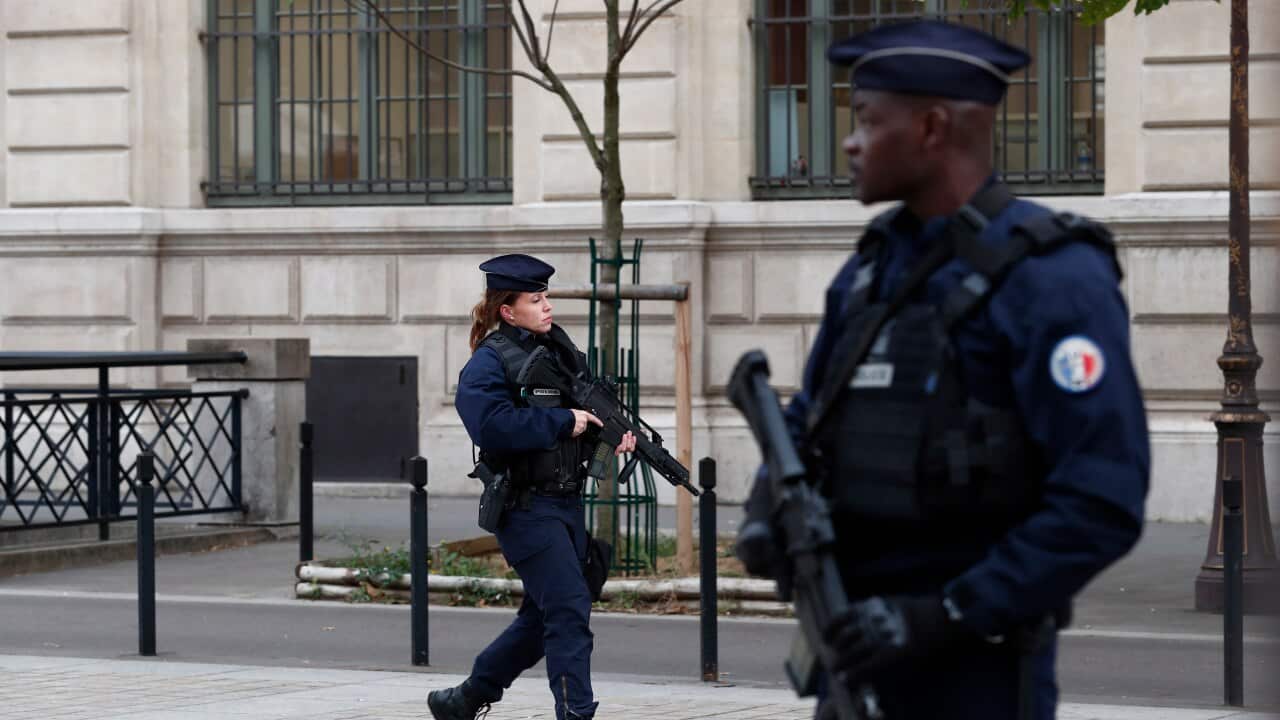 French police and security forces establish a security perimeter near the police headquarters where a man was attacking officers with a knife in Paris