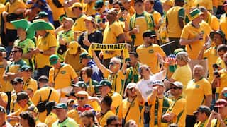 A crowd of Australian football fans dressed in green and gold