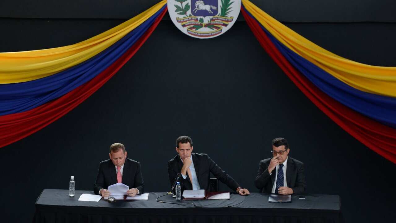 El líder de la oposición, Juan Guaidó, en el centro, junto a sus colegas legisladores Juan Pablo Guanipa (izq.) y Carlos Eduardo Berrizbeitia (der.) mientras realizan una sesión en un teatro en el barrio de El Hatillo.