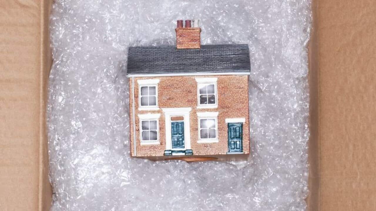 Model of house on bubble wrap in packing carton view from above