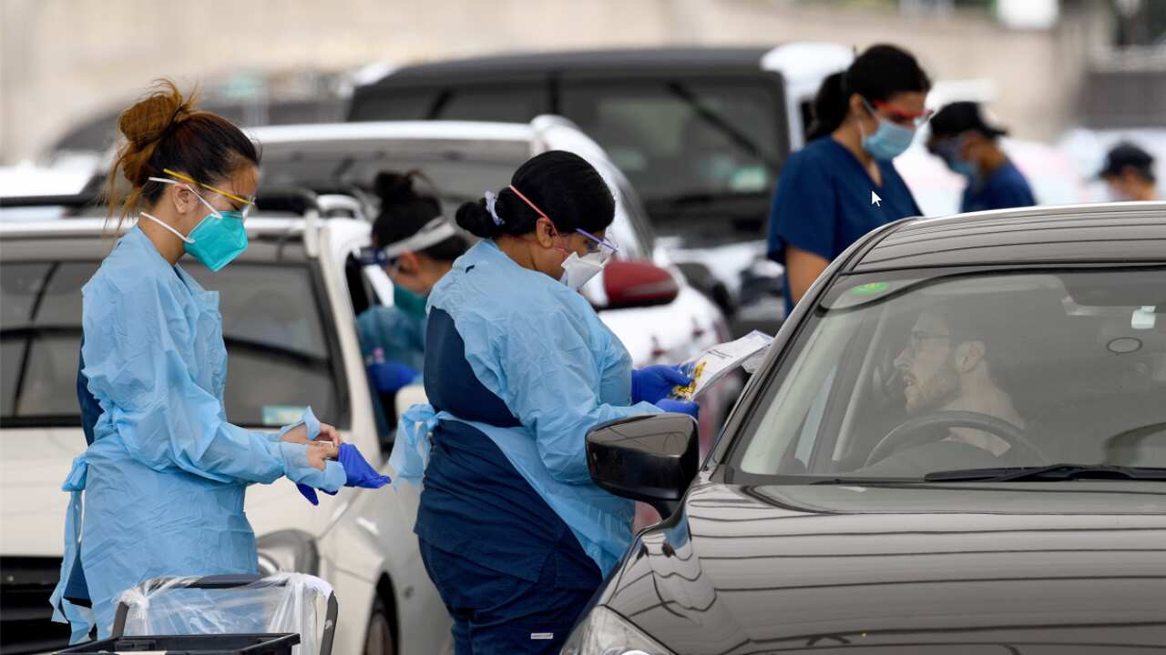 Healthcare workers administer COVID-19 tests at the St Vincent’s Hospital drive-through testing clinic at Bondi Beach in Sydney, as case numbers surge.