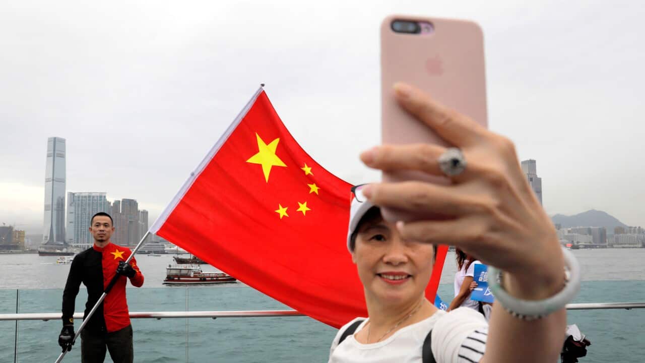 Pro-China supporters take a selfie with a Chinese national flag during a rally at a park in Hong Kong