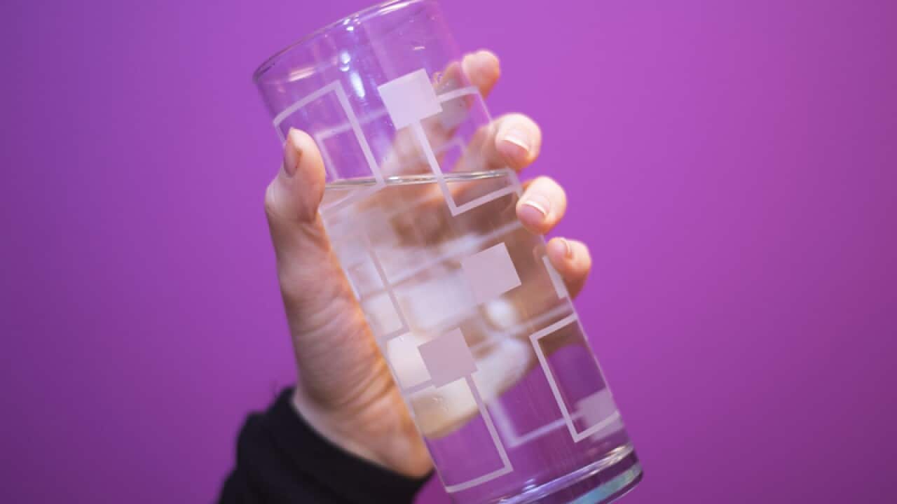 Someone holding a glass of water